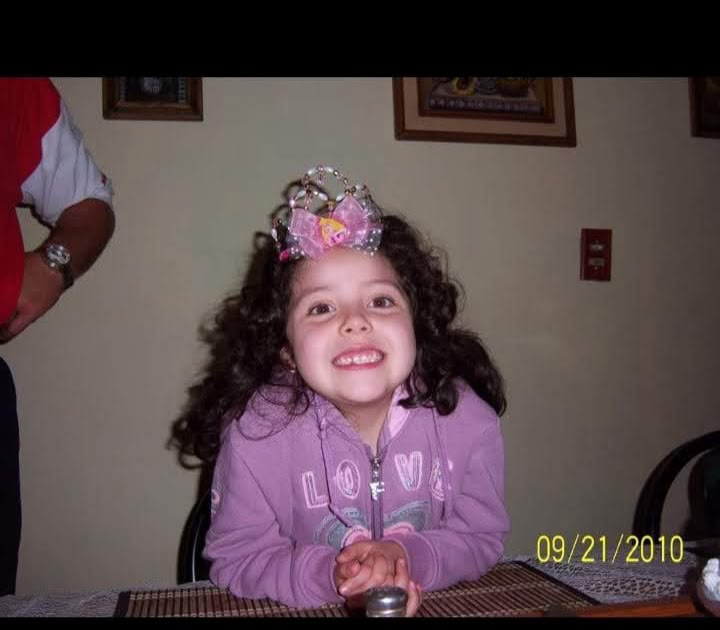 Fotografía de la festejada cuando era niña, sonriendo con una corona